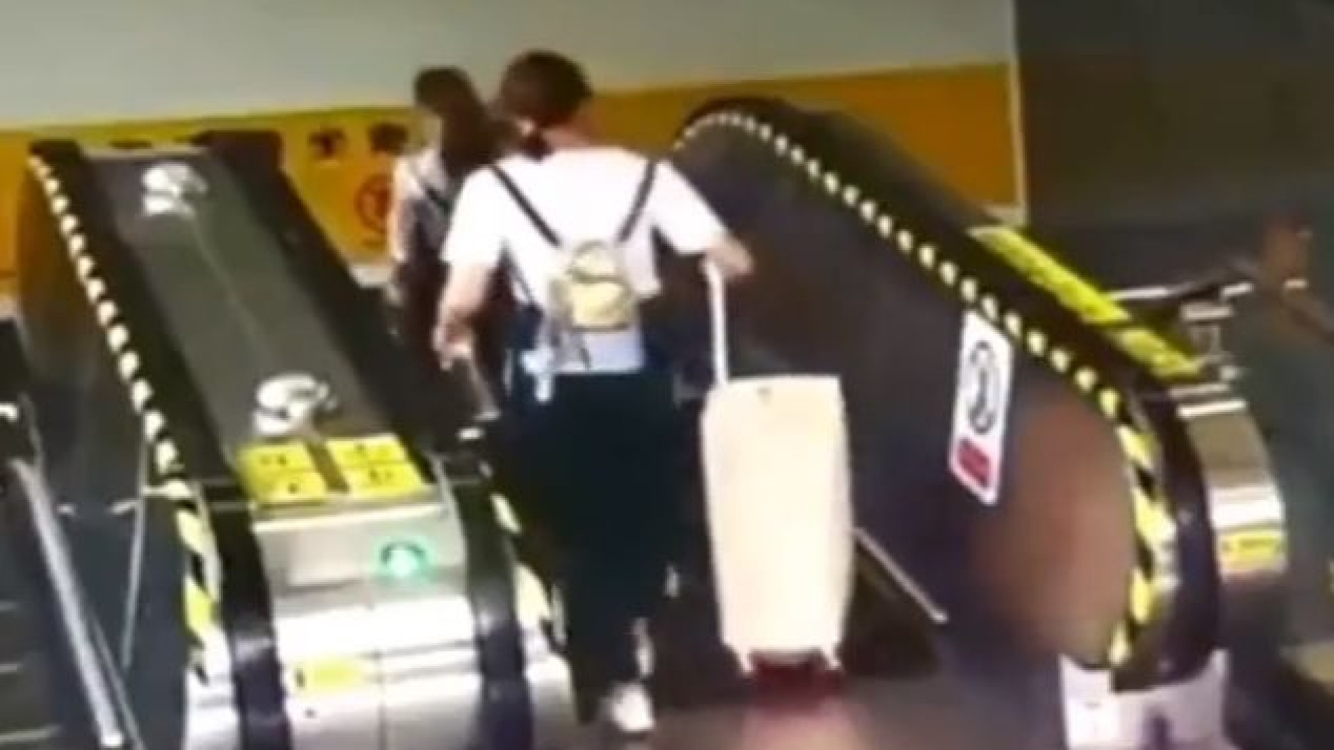 Mulher derrubada em escada rolante por... uma mala