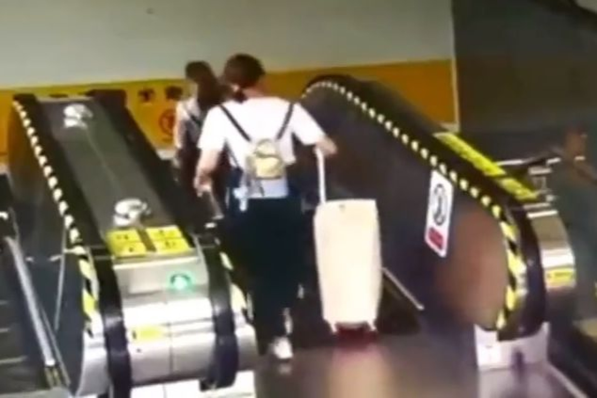 Mulher derrubada em escada rolante por... uma mala