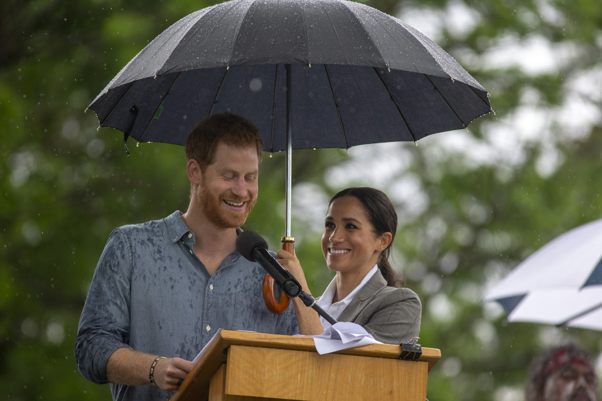O momento adorável em que Meghan Markle tenta proteger Harry da chuva