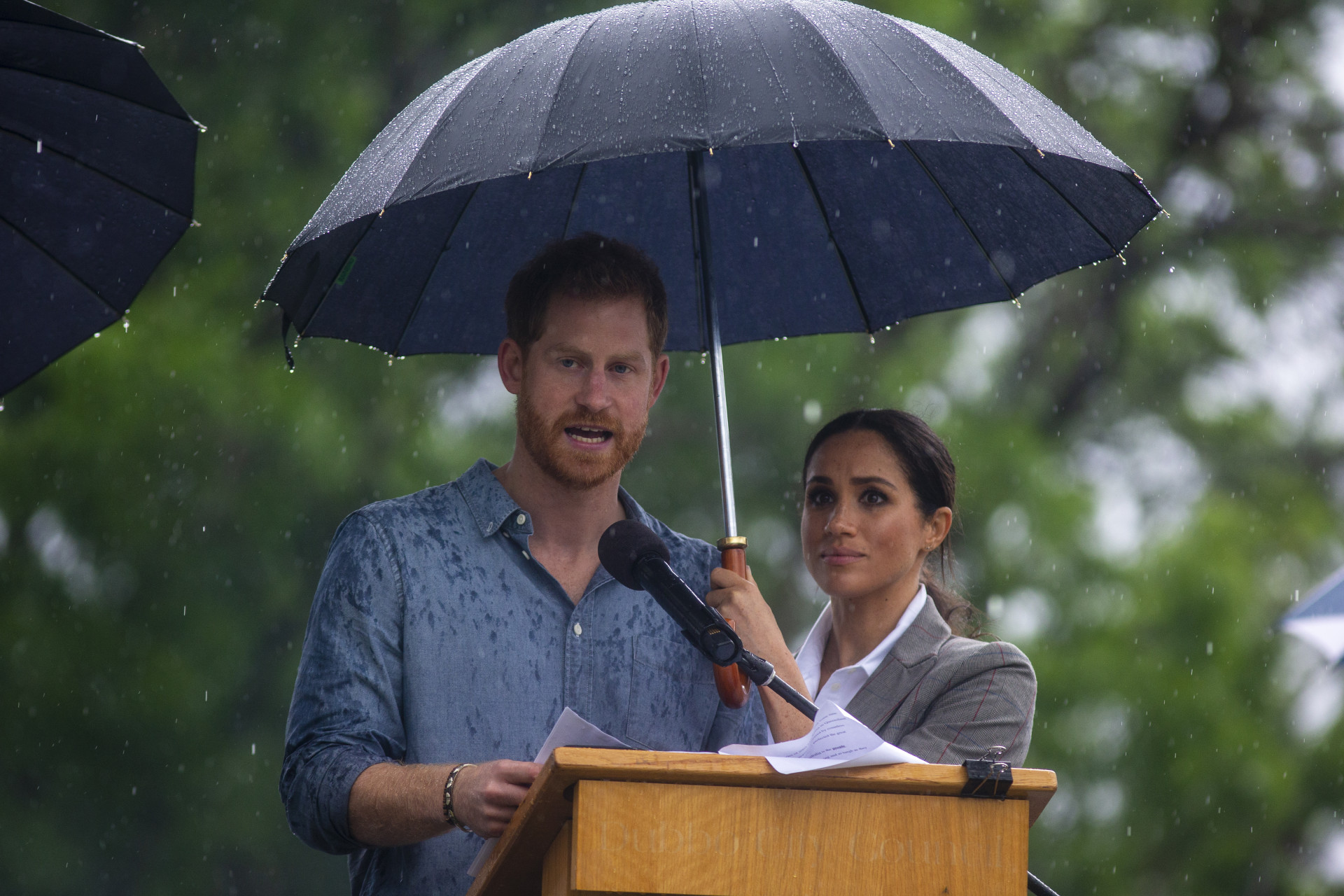 O momento adorável em que Meghan Markle tenta proteger Harry da chuva