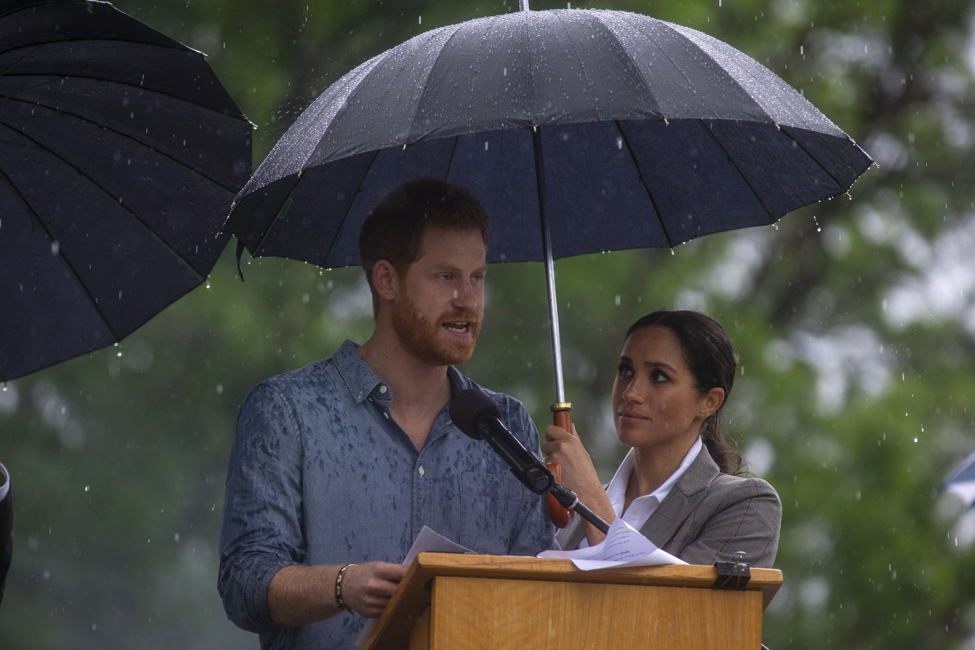 O momento adorável em que Meghan Markle tenta proteger Harry da chuva