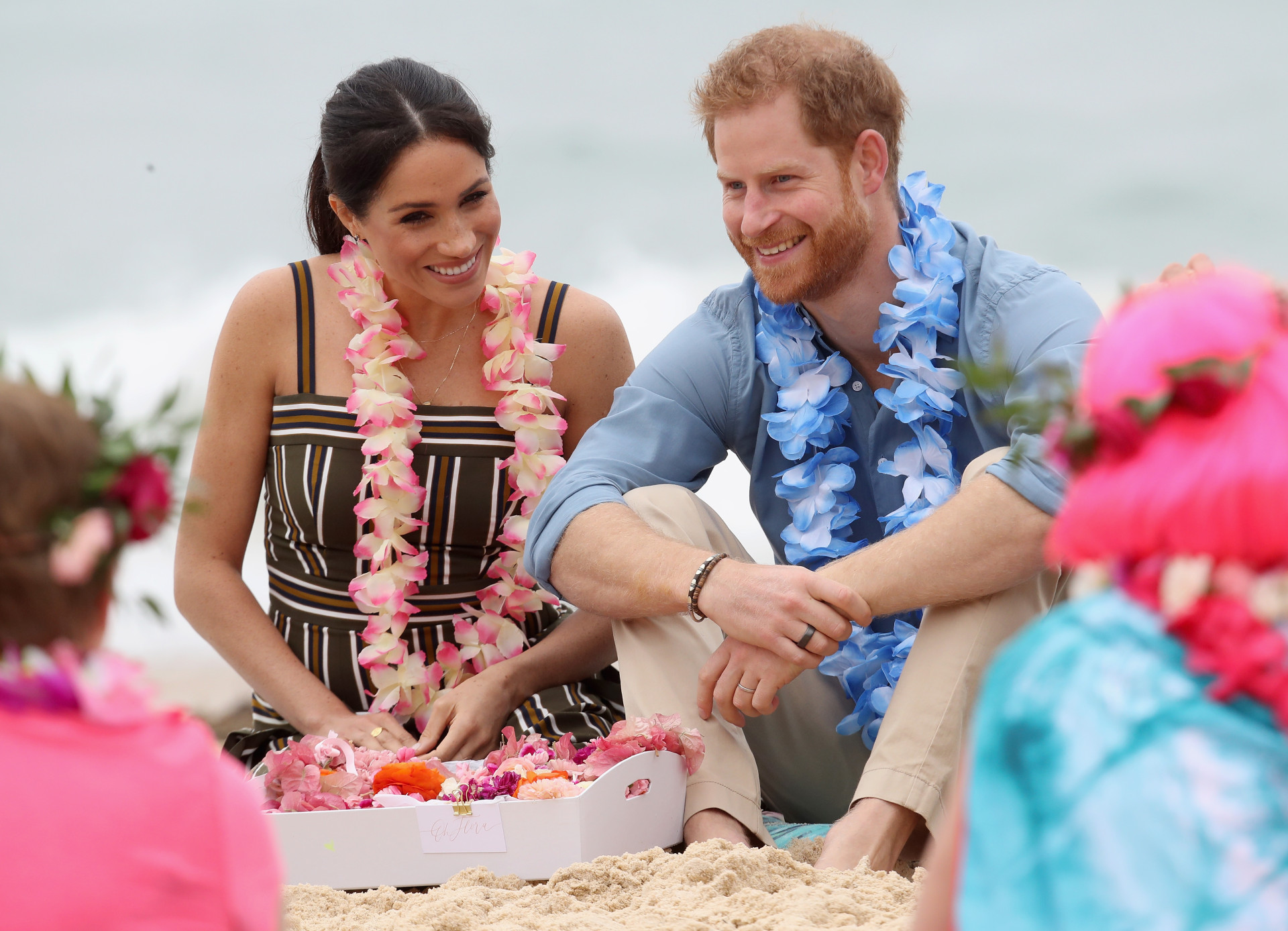 Pé na areia e coroas de flores: A visita oficial de Meghan Markle e Harry