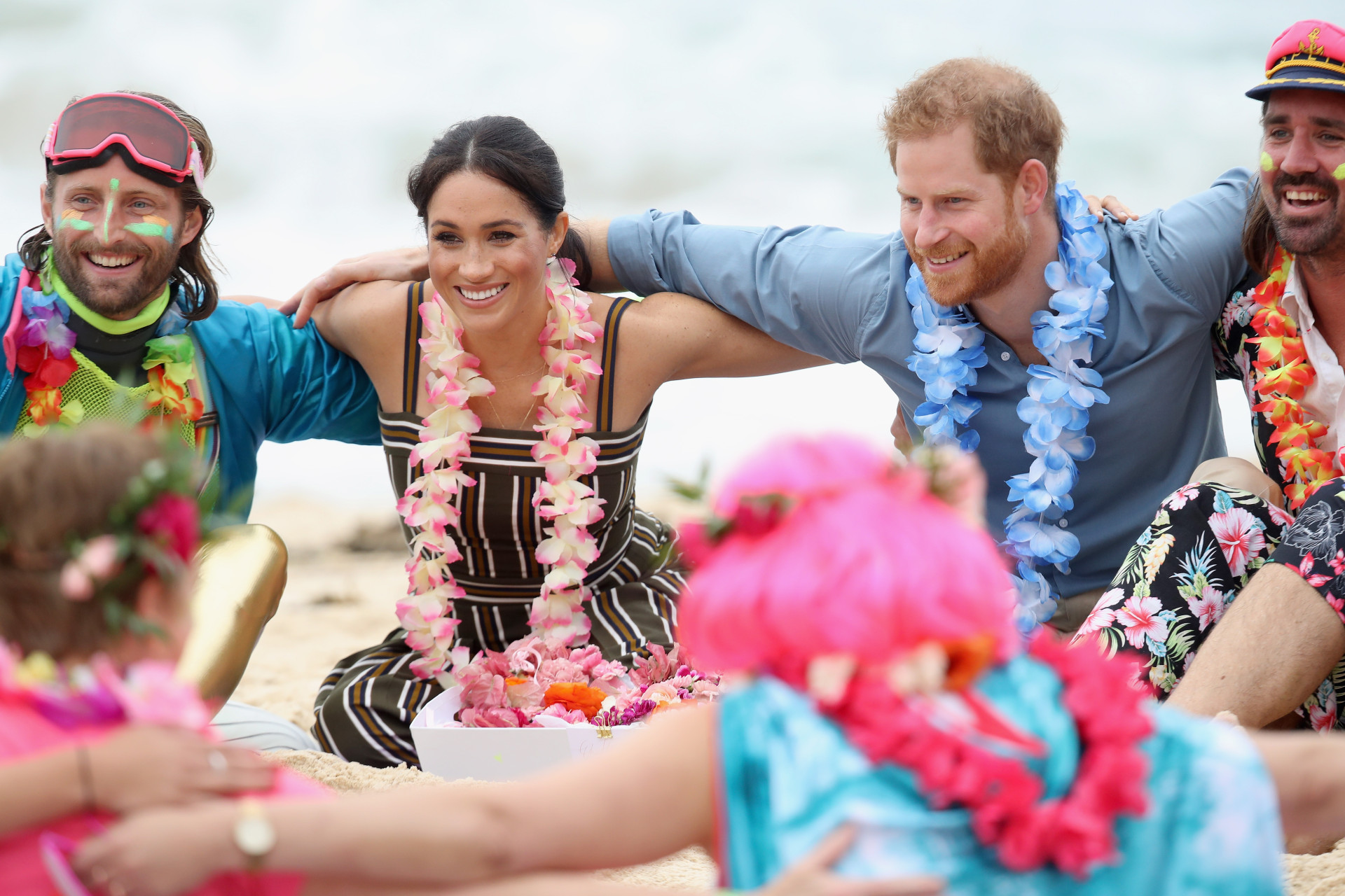 Pé na areia e coroas de flores: A visita oficial de Meghan Markle e Harry